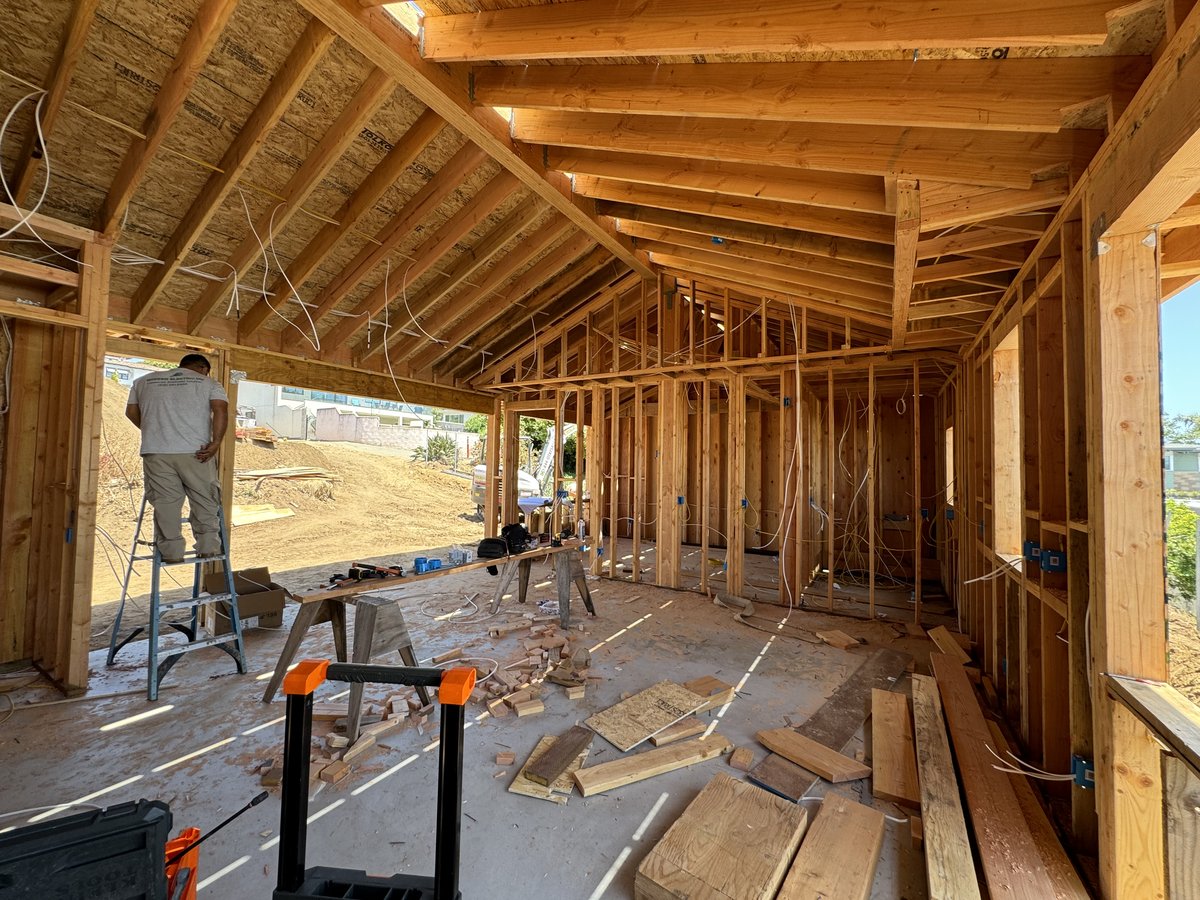 Interior wood framing with worker on ladder